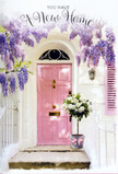 A pink front door in Harrow becomes a symbol of fresh beginnings in this softly lit entrance scene, composed with the sensitivity of an experienced florist. The door, painted in a gentle blush tone, sits within a whitewashed wall that reflects the afternoon light, making the entrance feel bright and welcoming, like a hidden gem off a peaceful street near North Harrow or Sudbury Hill. Above, cascades of wisteria spill down from an unseen pergola, their blossoms forming layers of lavender, lilac, and dusky purple that sway visually like a fragrant curtain. The tendrils frame the doorway so that the eye is drawn to the step, where a stylish grey tin bucket has been placed with purpose. This bucket overflows with lush white and cream roses, their petals opening into soft, rounded cups that speak of careful nurturing and freshness. Interlaced with the roses, muted green foliage adds both contrast and softness, creating a bouquet that feels generous without being showy. A pale pink ribbon is tied around the bucket, its satin tail resting gently against the step, mirroring the colour palette of the door and unifying the whole composition. Light filters gently through the wisteria, casting faint, dappling shadows on the door and threshold, suggesting the calm of a late afternoon as someone prepares to move in. The emotional tone is one of quiet joy and reassurance, making this image ideal for a new home greeting, a Harrow housewarming bouquet, or any moment when you want flowers to say, You're welcome here, and this place is already starting to feel like yours.